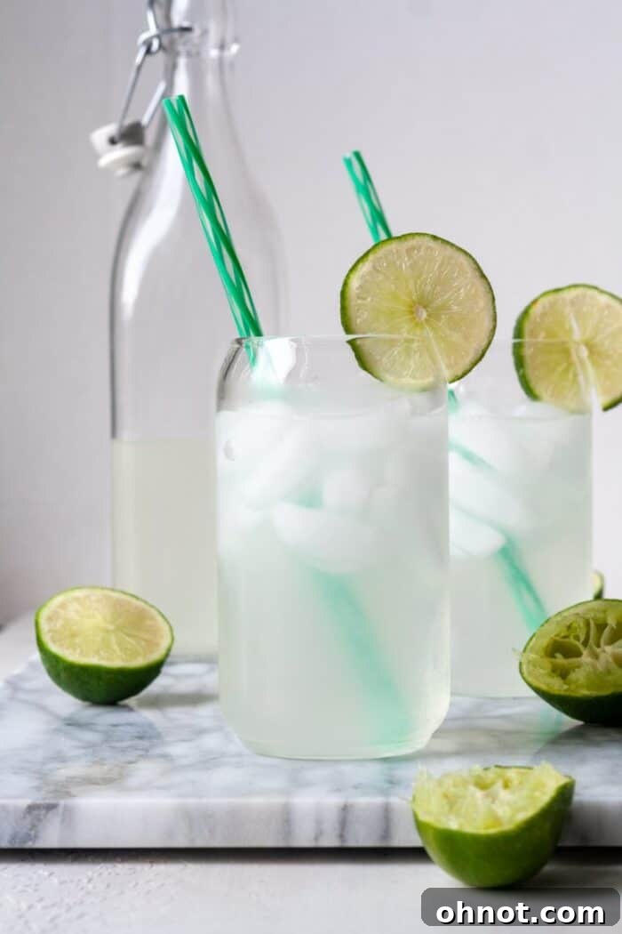 Glasses of lime juice with sliced lime garnishes, ready to be served.