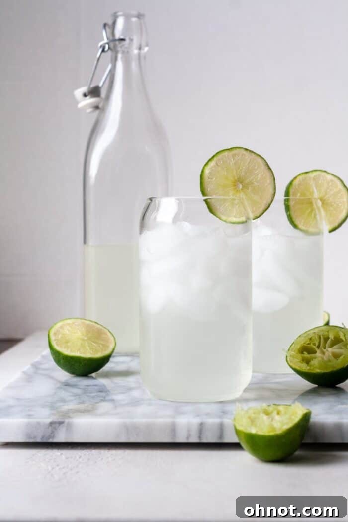 Multiple glasses filled with homemade limeade, ice, and lime slices.