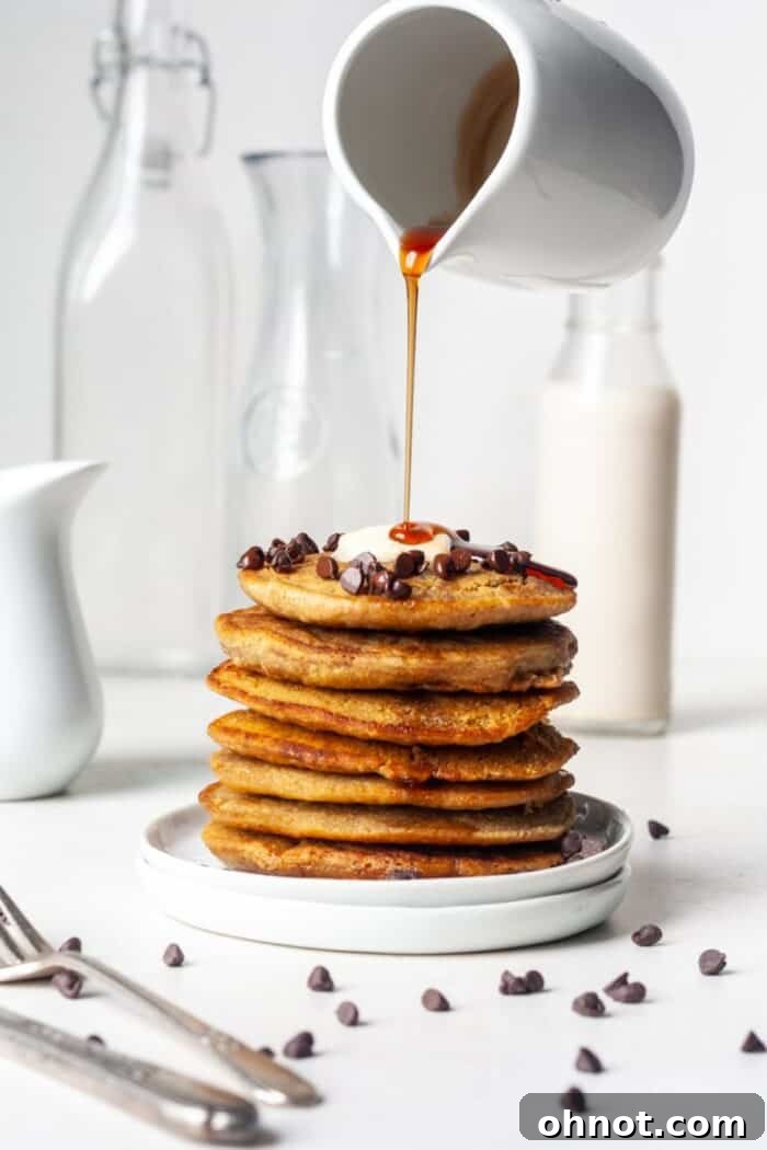 Fluffy oat flour pancakes with syrup pour