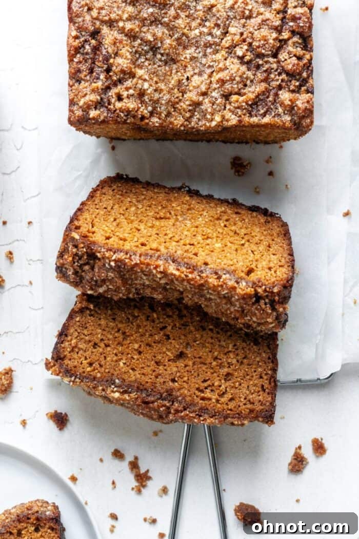 A rustic cutting board displaying several slices of freshly baked Paleo pumpkin bread, ready to be served.