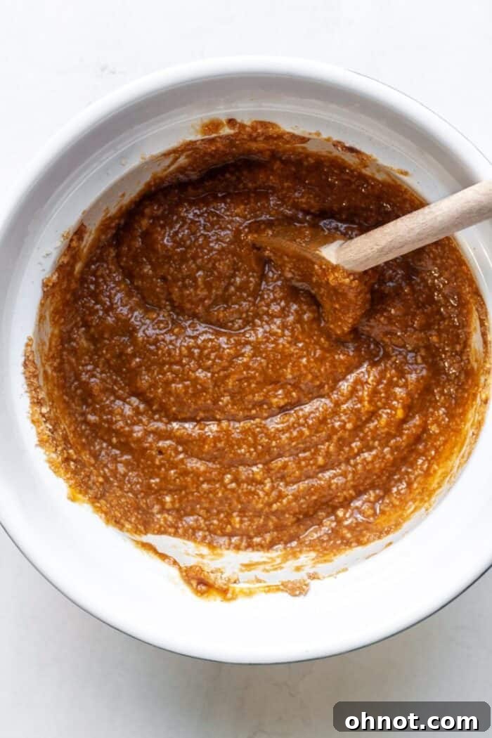 Close-up of pumpkin batter in a mixing bowl after dry ingredients have been added and stirred.