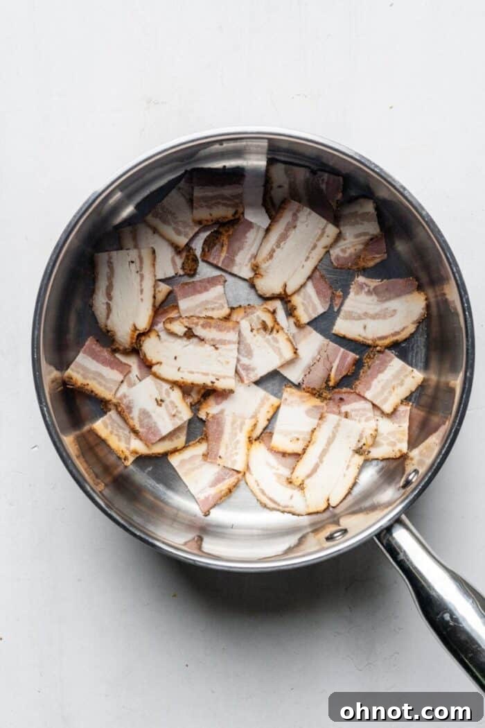 Sliced raw bacon in a pot, ready to be cooked