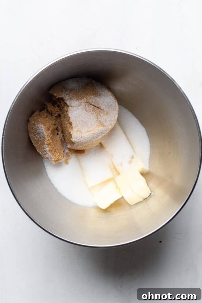 Cold butter and sugars being creamed in a mixing bowl