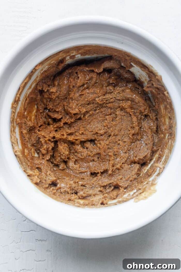 Healthy cookie dough with egg, vanilla, and baking soda mixed in a bowl.