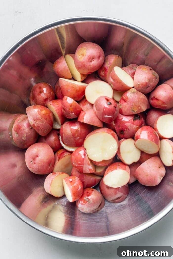 Red potatoes expertly diced into 1-inch cubes and placed in a bowl, ready for seasoning