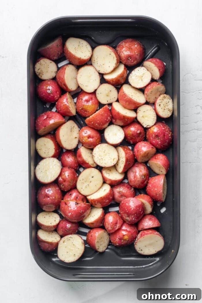 Diced potato cubes arranged in a single, even layer inside an air fryer basket, ready for cooking
