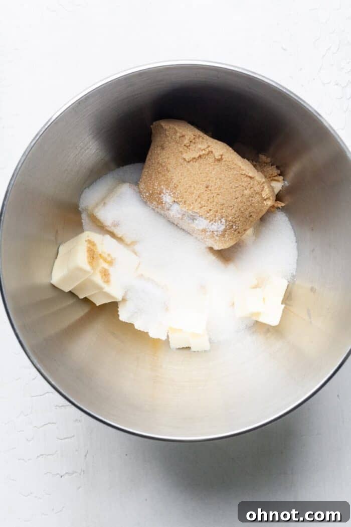 Mixing bowl with cold butter cubes and sugars ready to be creamed.