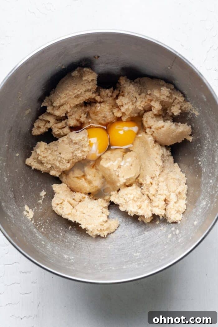 Cookie dough in a bowl after adding eggs and vanilla, before mixing.