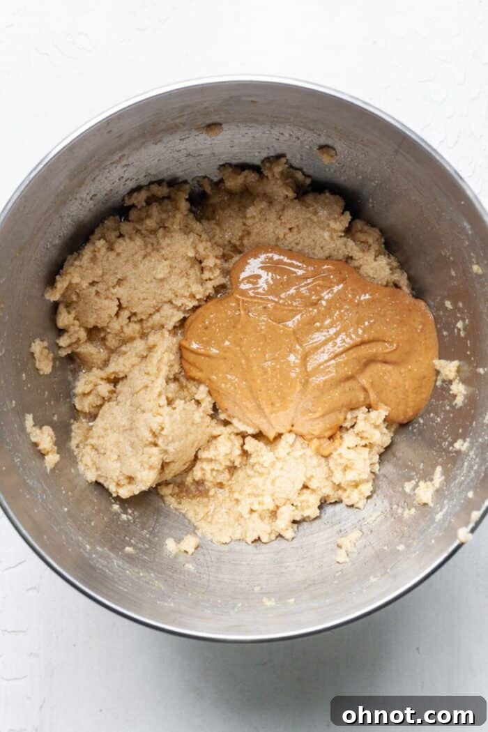 Peanut butter added to the wet ingredients in the mixing bowl.