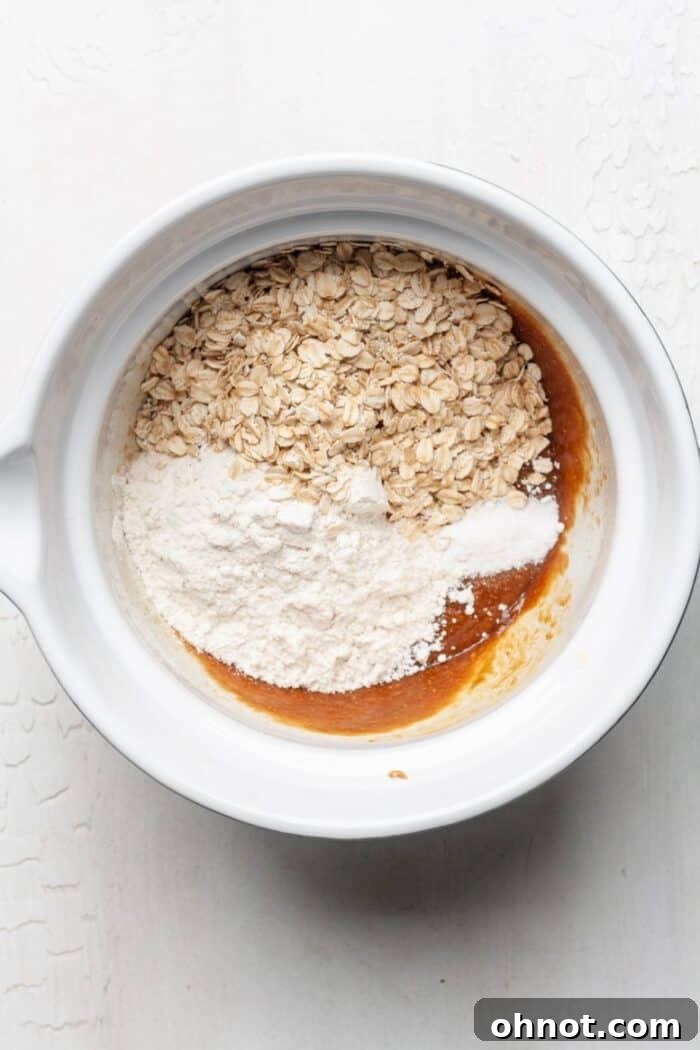 Peanut butter oat cookie dough in bowl, showing the texture before chocolate chips are added.