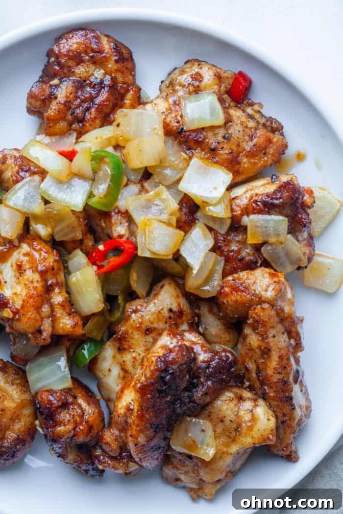 Salt and pepper chicken thighs with peppers on plate