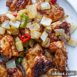 Salt and pepper chicken thighs with peppers on plate