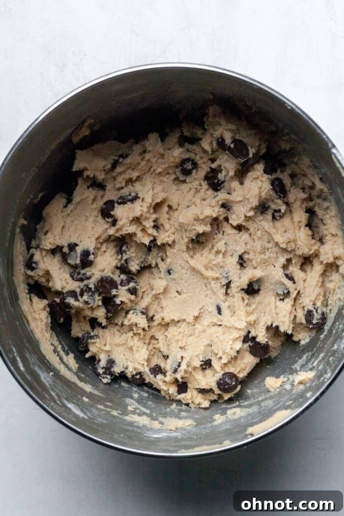 Egg free cookie dough with dark chocolate chips folded in, ready to be scooped.