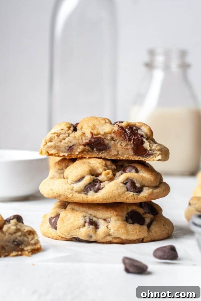 Freshly baked eggless chocolate chip cookies, served with a glass of almond milk, highlighting their inviting texture.