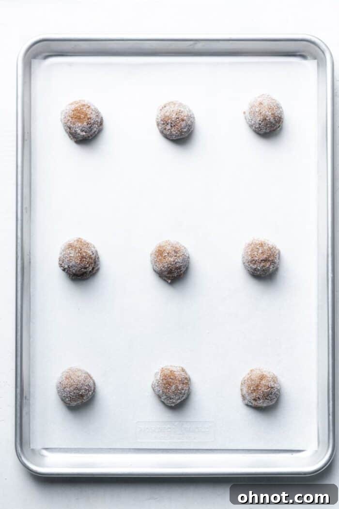 Baking pan with neatly spaced balls of vegan ginger cookie dough.