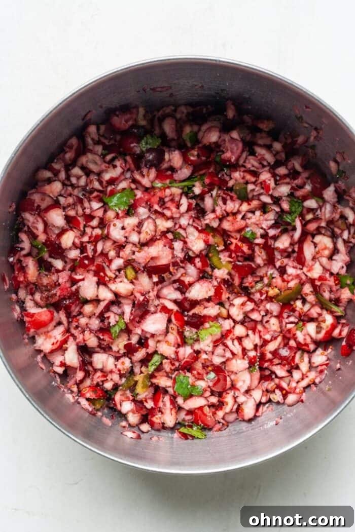 Cranberry mixture tossed with sugar and lime juice, showing a glistening coating on the berries