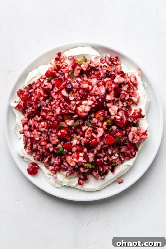 Finished cranberry jalapeño dip with cranberry mixture layered over cream cheese, ready to serve