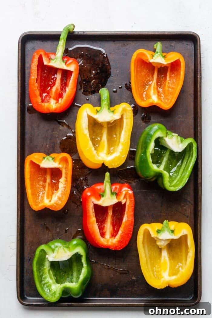 Bell pepper halves arranged on a baking sheet, drizzled with olive oil.