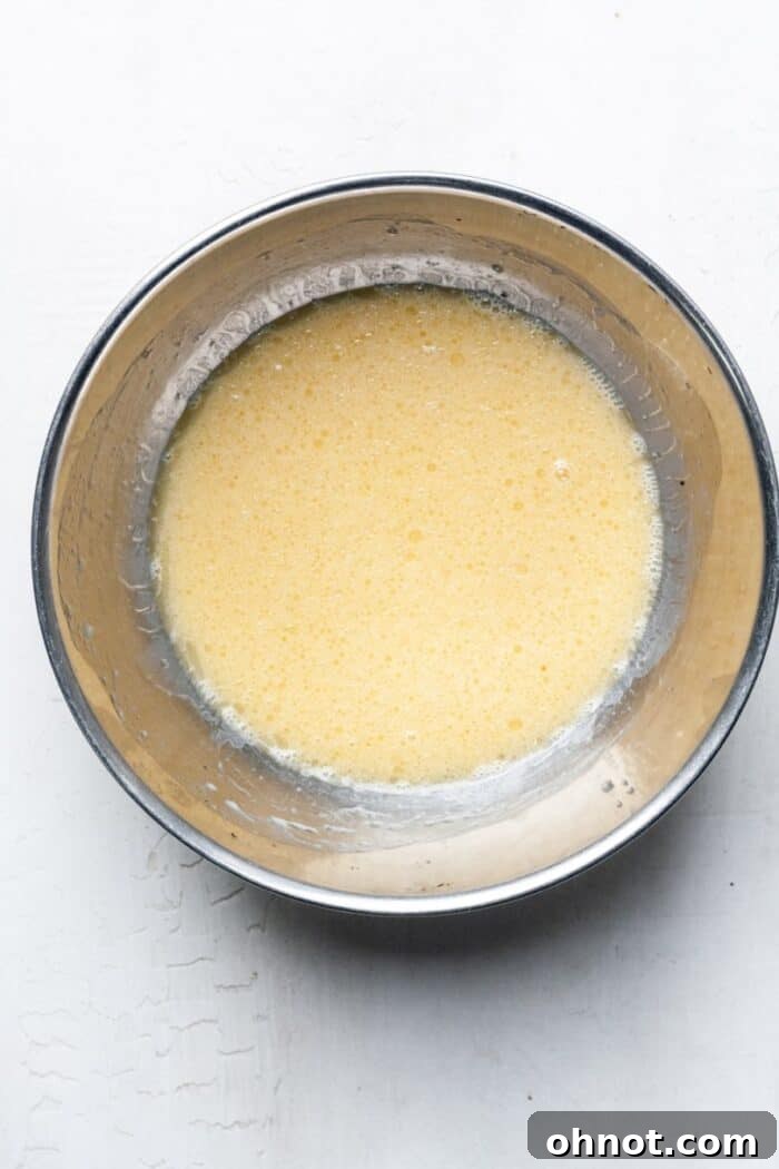 Thin, well-combined liquid batter in a mixing bowl, ready for dry ingredients.