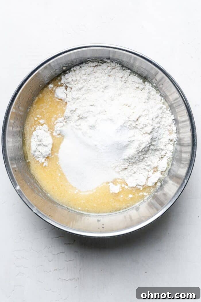Thick, vanilla-scented donut batter being mixed in a bowl, showing a smooth consistency.