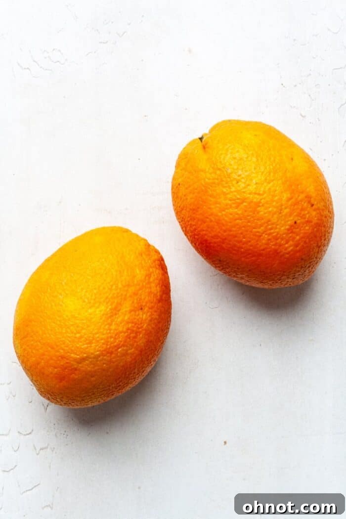 Fresh, vibrant oranges ready for preparation on a wooden surface.