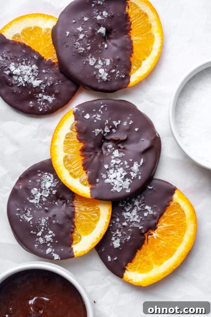 Beautifully arranged dark chocolate covered orange slices on a white background.
