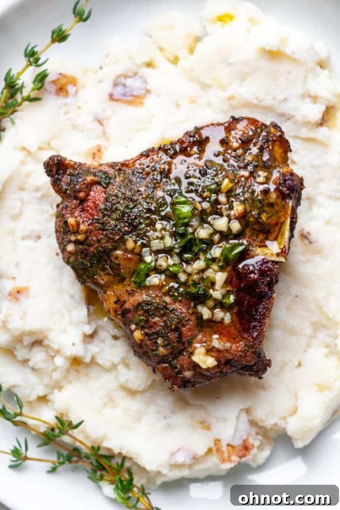 Cooked lamb chops with creamy mashed potatoes and thyme garnish