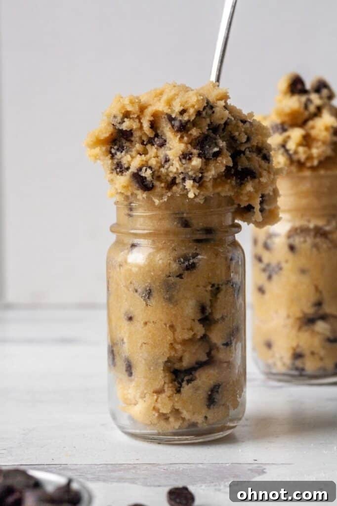 A bowl of edible cookie dough, served with a spoon and ready for enjoyment.