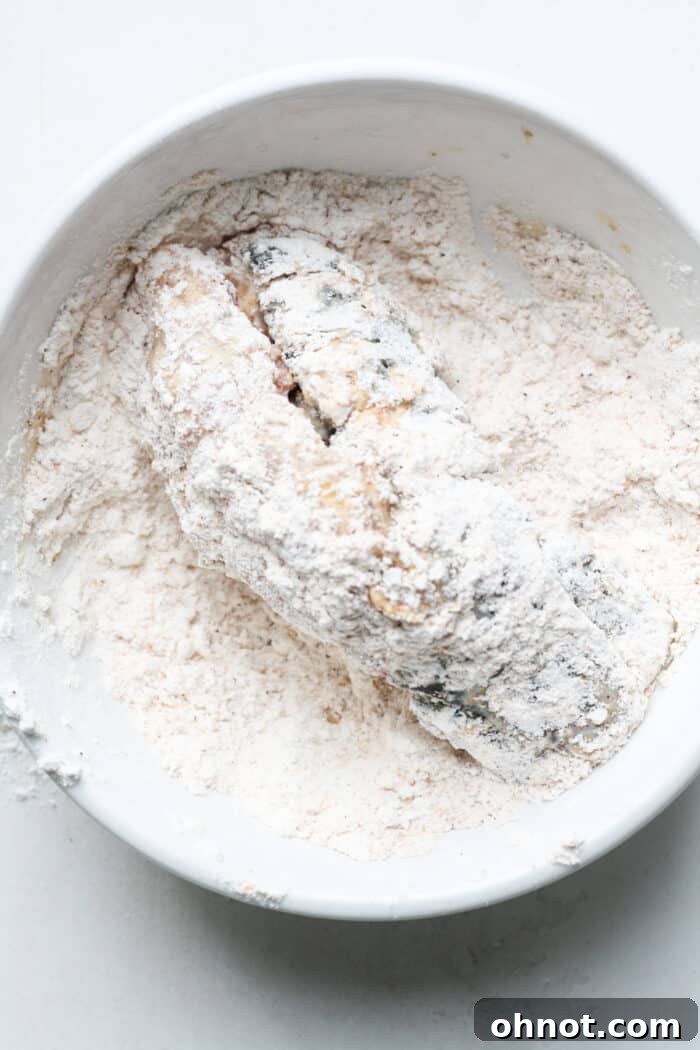 Lobster tail after its second coating in the dry flour mixture, ready for frying.