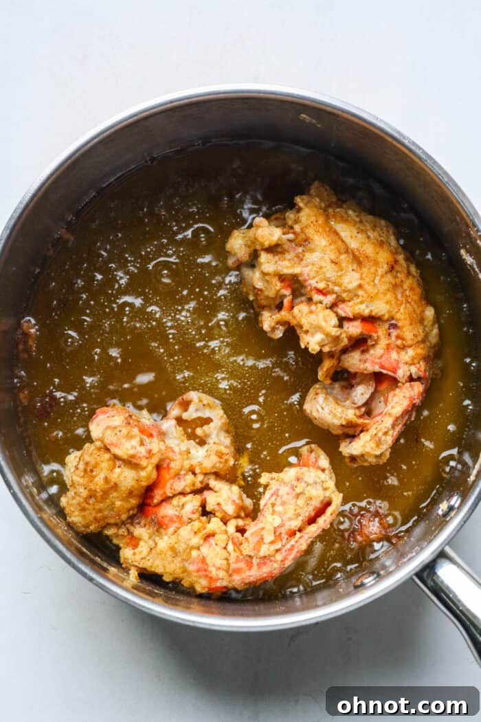 Fried lobster tails bubbling in hot oil, turning golden and crispy.