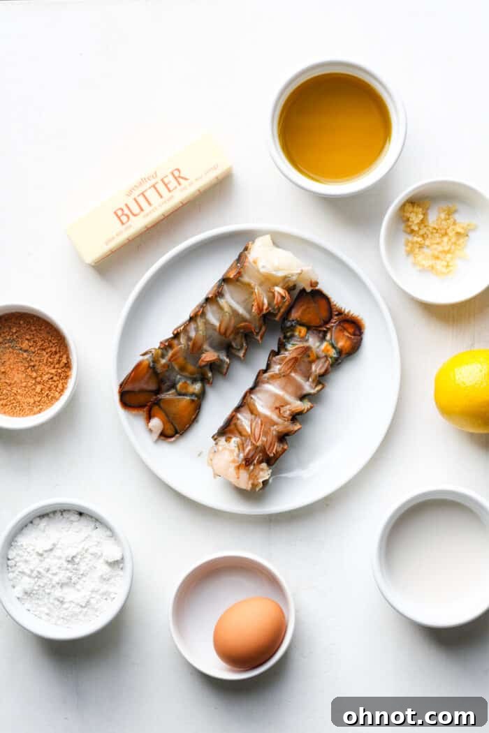 Ingredients laid out for fried lobster tails, including flour, eggs, milk, oil, and Old Bay seasoning.