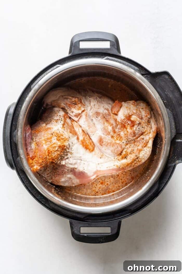 Instant Pot with pork and seasonings before pressure cooking