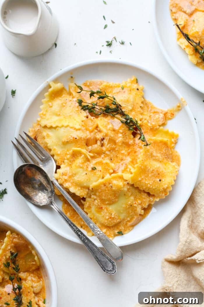 Creamy lobster ravioli sauce on a white plate, garnished with fresh herbs.