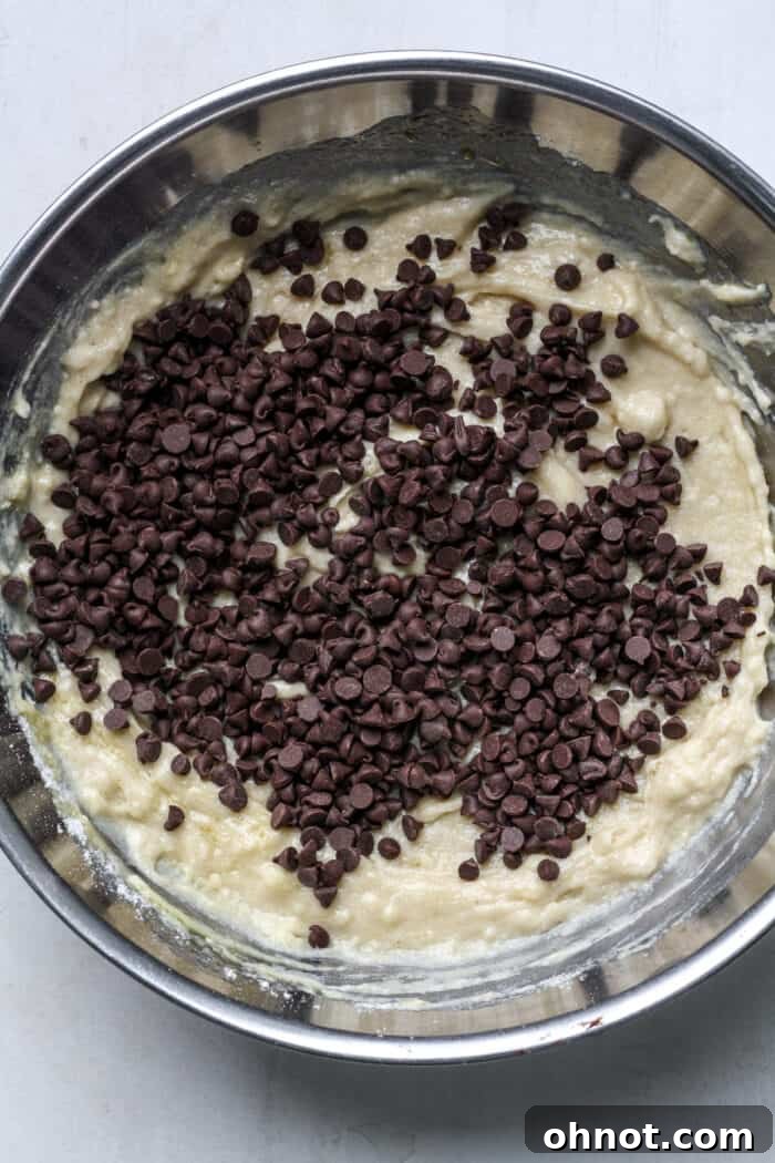 Vegan chocolate chips being folded into the muffin batter.