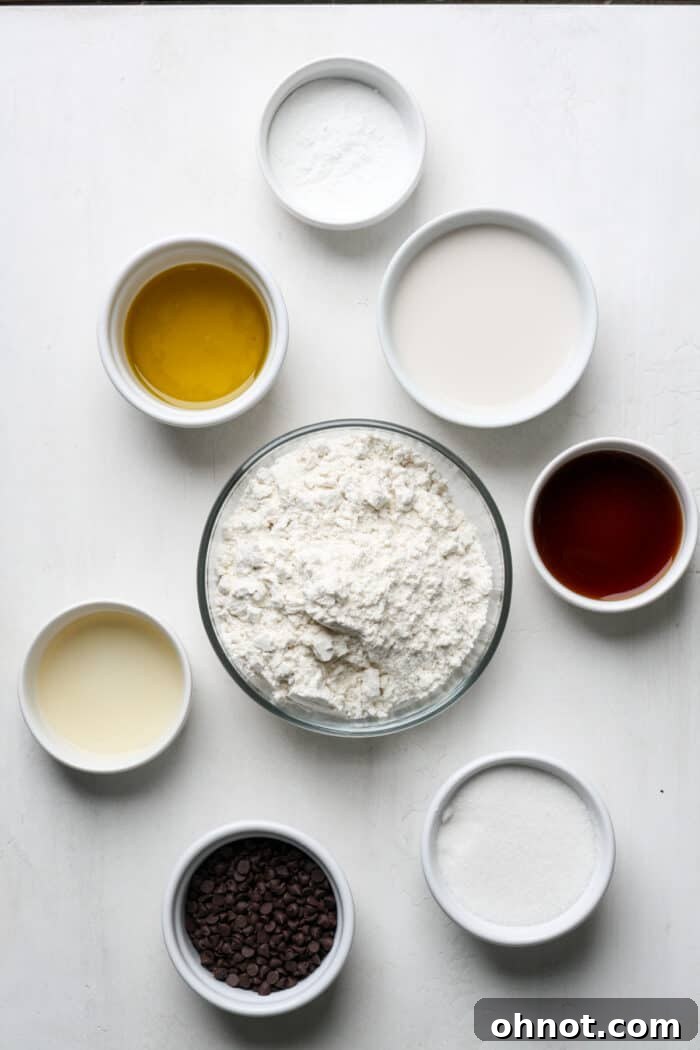 Various muffin ingredients displayed in white bowls on a wooden surface.