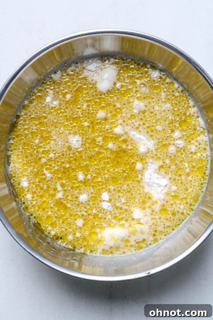 The wet mixture being poured into the dry ingredients.