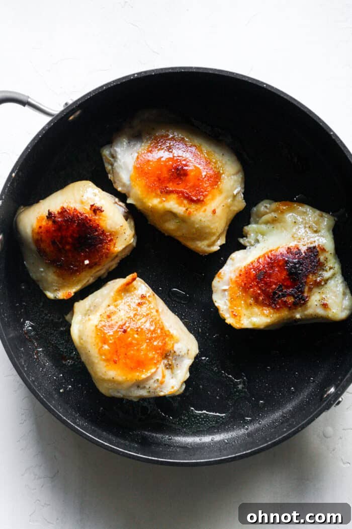 Skillet with crispy, seared sous vide chicken thighs