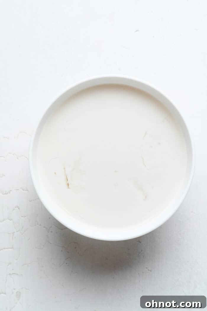 Curdled almond milk and apple cider vinegar mixture in a bowl, resembling buttermilk.