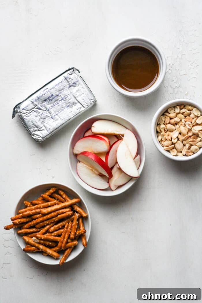 Close-up of a bowl filled with creamy caramel apple dip, garnished with a sprinkle of nuts, beside an assortment of fresh fruit slices and crackers, ready for dipping.