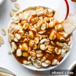 Caramel apple dip with sliced apples in white bowl