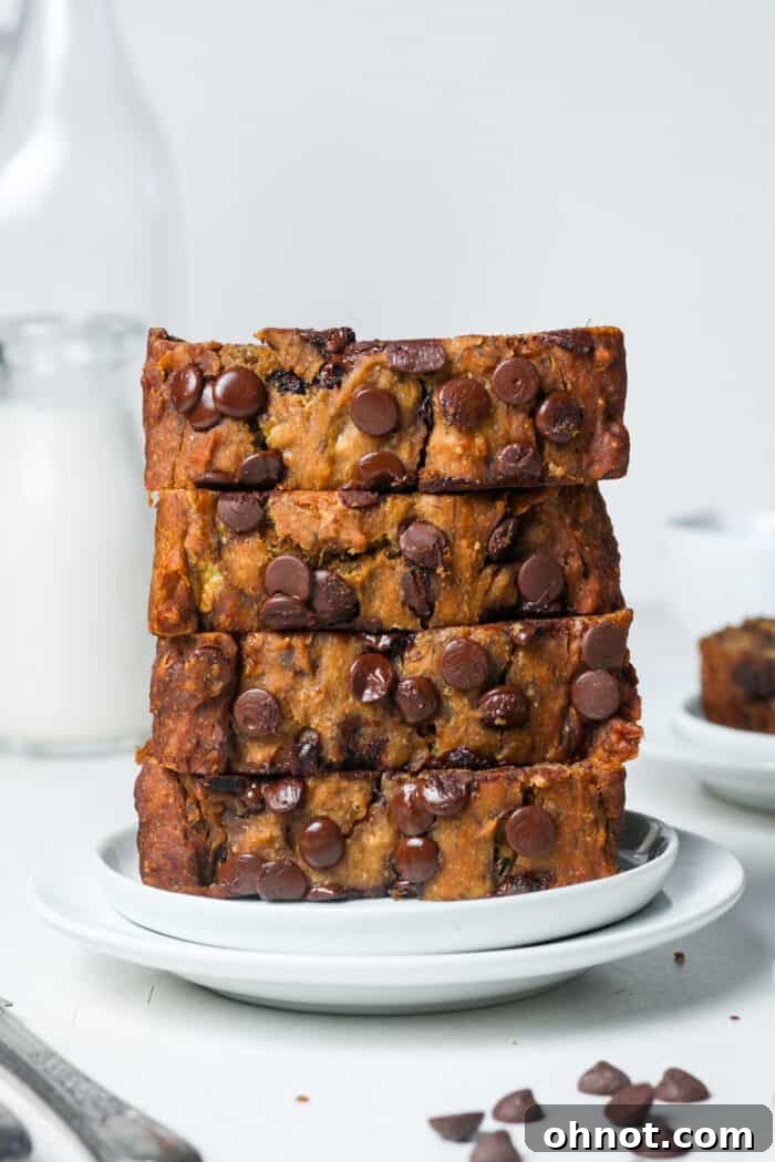 Irresistible Vegan chocolate chip banana bread loaf, golden brown and speckled with chocolate chips, ready to be sliced and enjoyed.