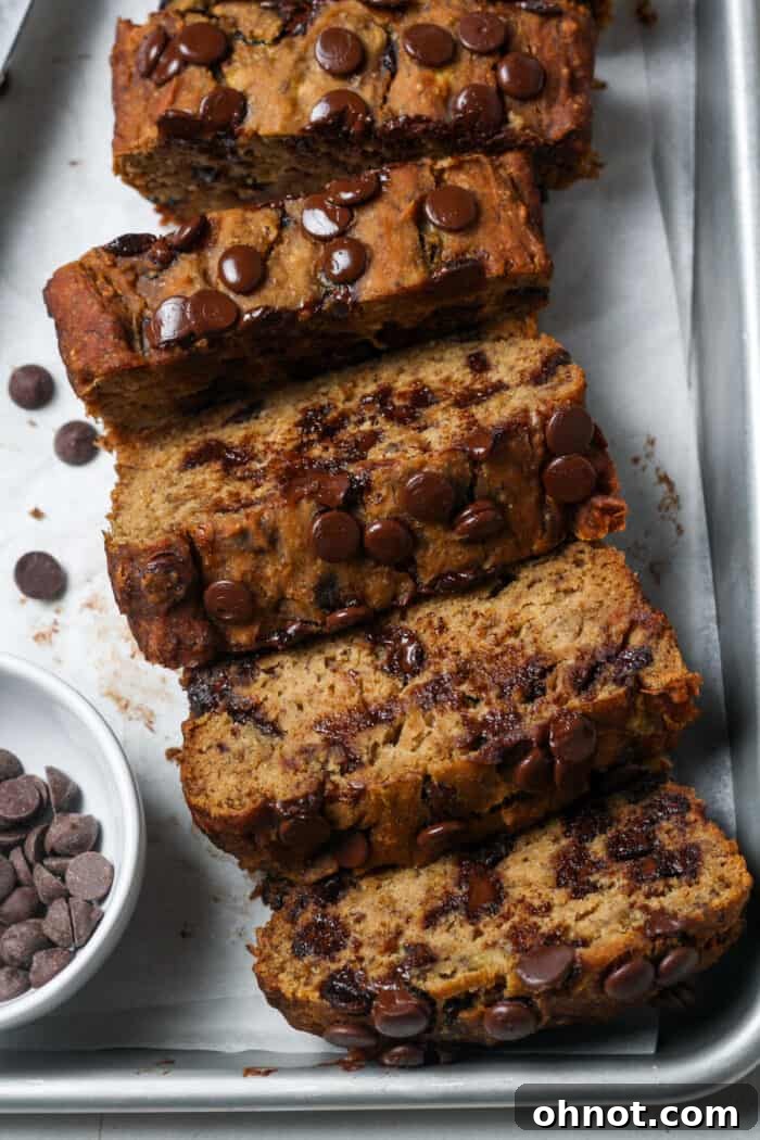 A slice of moist Vegan banana bread studded with dark chocolate chips, perfectly baked.