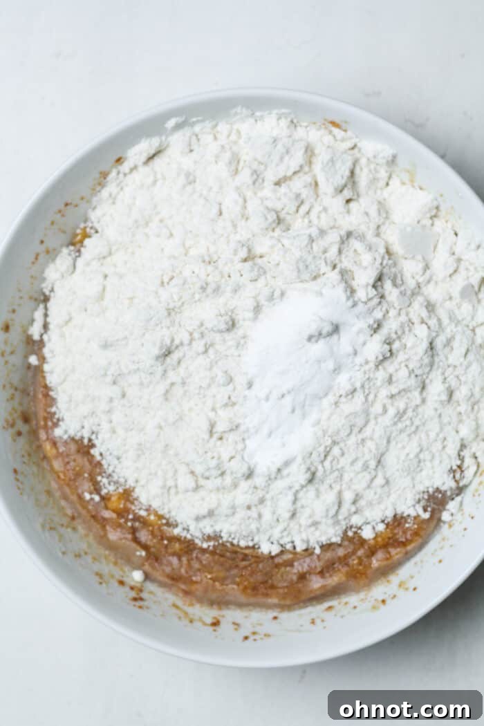 Dry ingredients like flour, baking soda, and salt measured in a small white bowl.