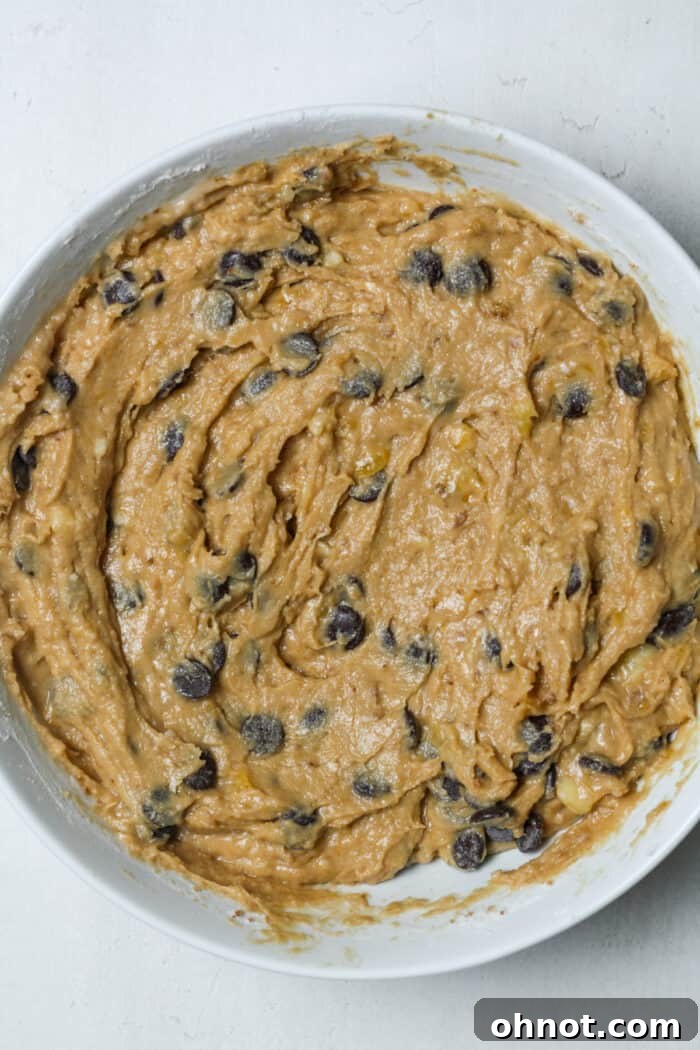 Banana bread batter with evenly distributed chocolate chips in a mixing bowl.