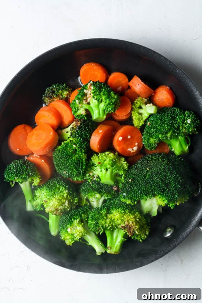 Broccoli and carrots reaching tenderness in the pan