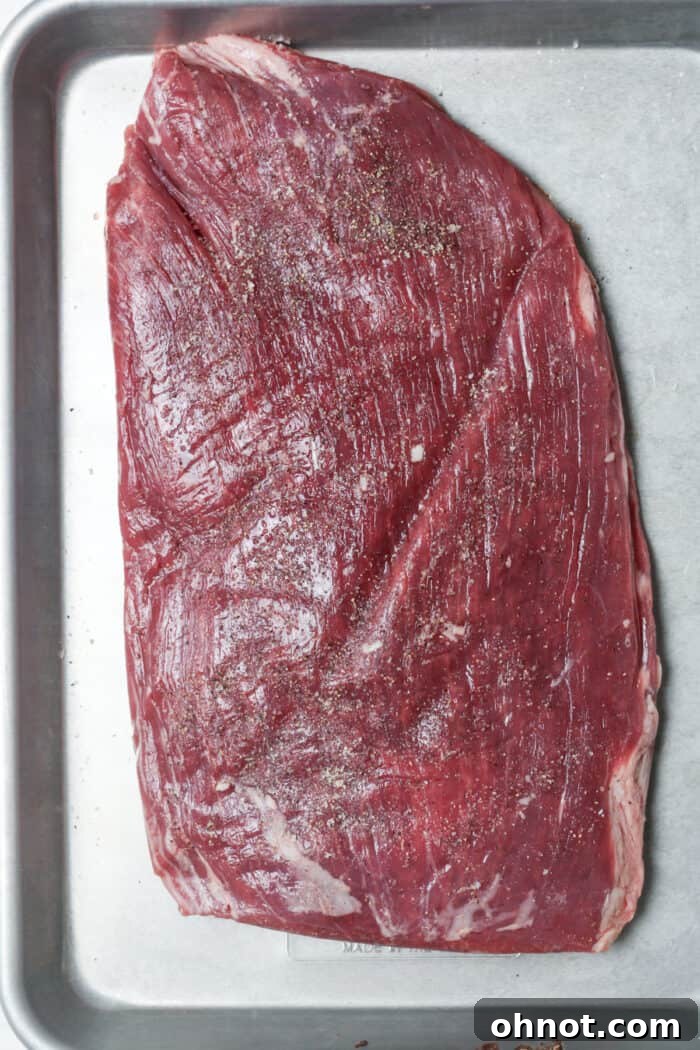 Seasoned flank steak on pan