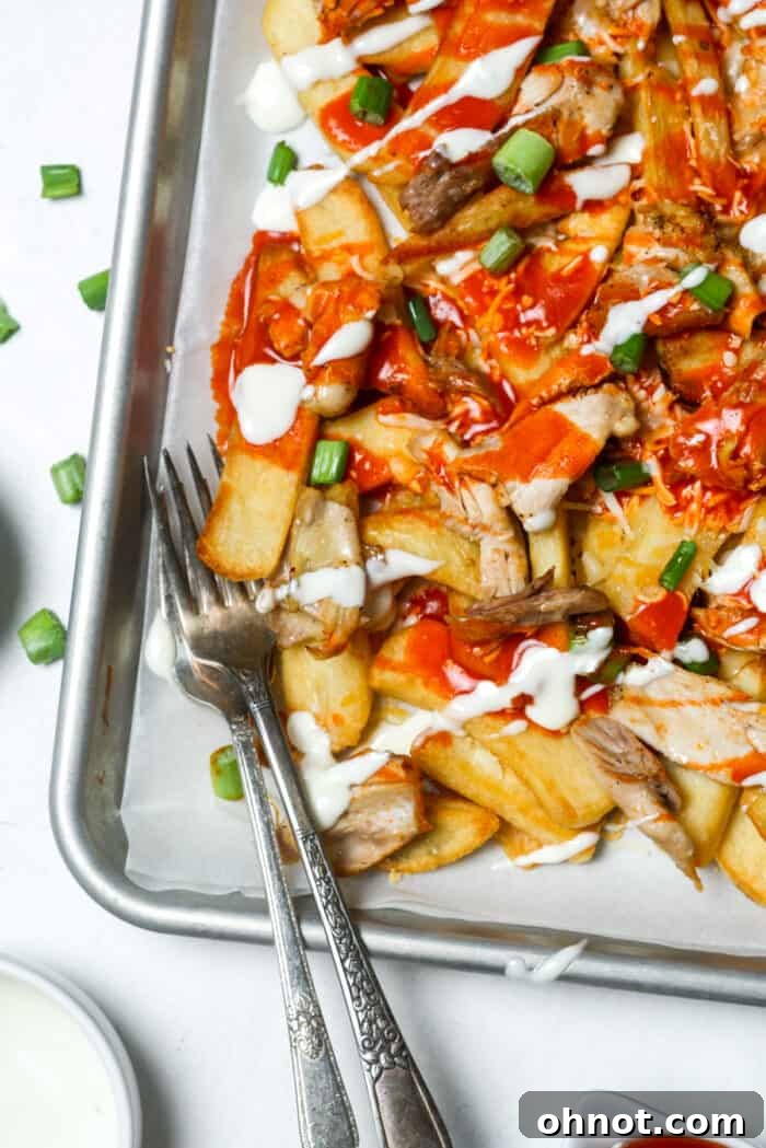 Buffalo chicken fries being served with a fork, showing the rich, melted ingredients.