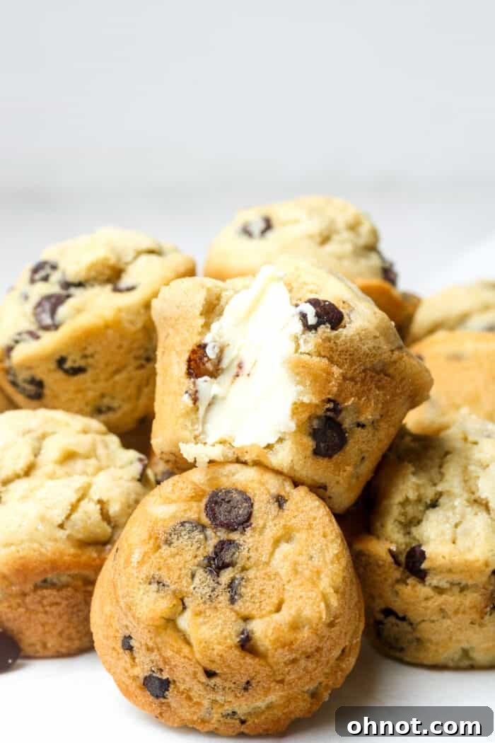 Beautifully baked gluten-free muffins, some split open revealing a buttery, chocolatey interior.