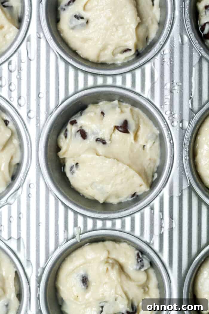 Muffin pan filled with chocolate chip batter, ready to go into the oven.