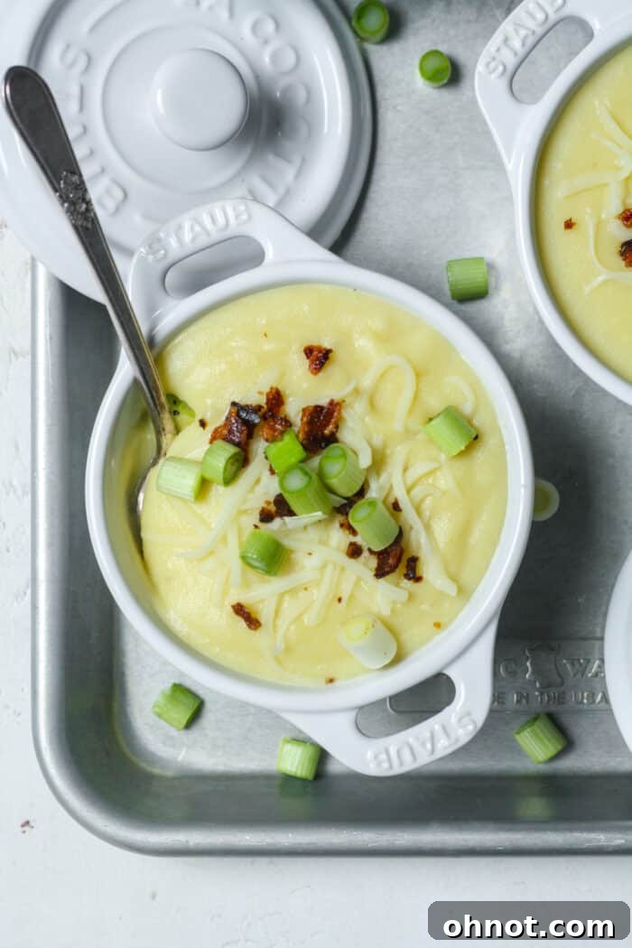 A beautifully presented bowl of creamy 4-ingredient potato soup, garnished with fresh herbs and a swirl of cream, ready to be enjoyed.